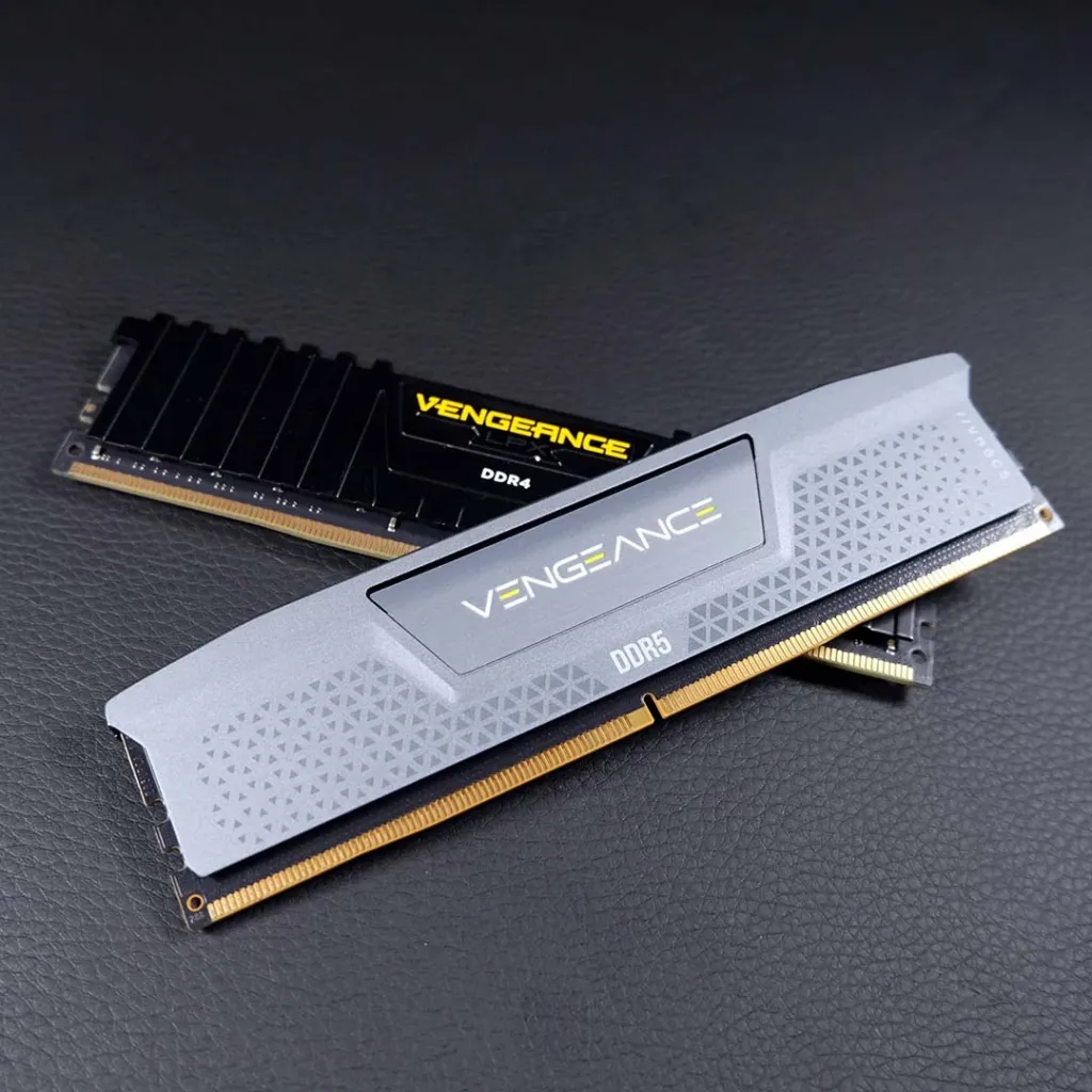 DDR4 vs DDR5 sticks A DDR4 memory stick photographed beneath a DDR5 memory stick, showing their similar size and different notch positions